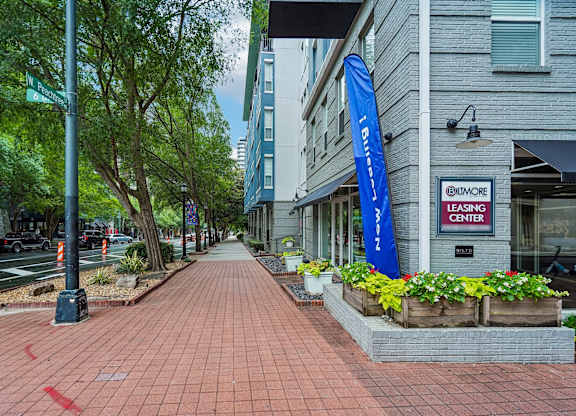 A brick sidewalk leads to a building with a sign that says