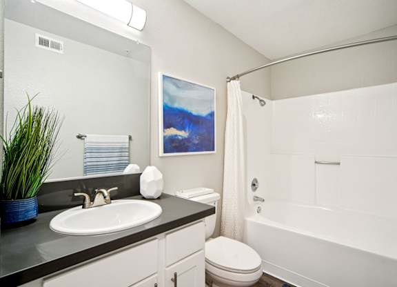 A bathroom with a white toilet, a white sink, and a white bathtub.
