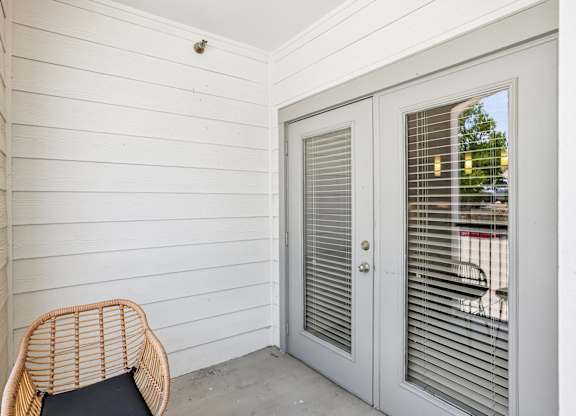 A white door with a window and a chair in front of it.