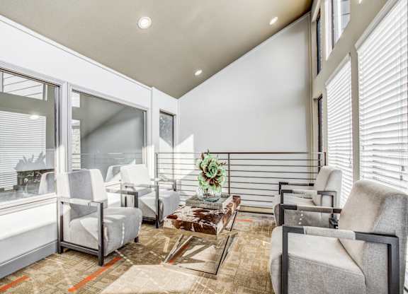 A living room with a couch, chairs, and a coffee table.