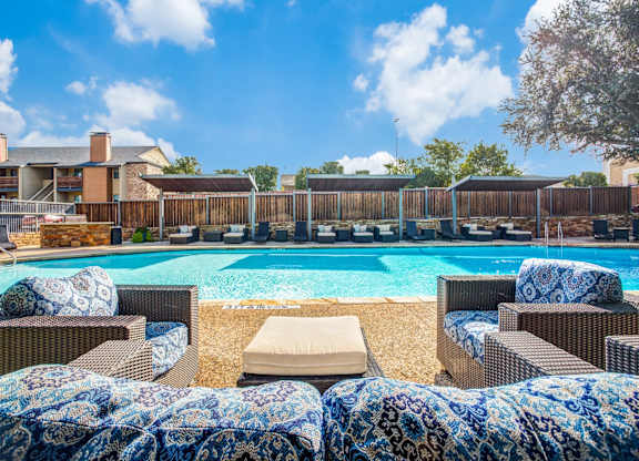 A pool surrounded by chairs with a blue and white blanket.