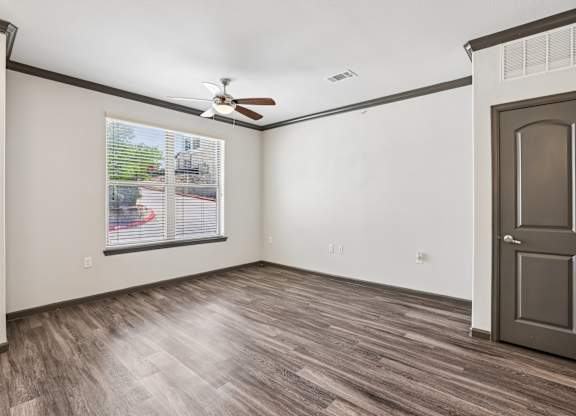 A room with a ceiling fan and a door.