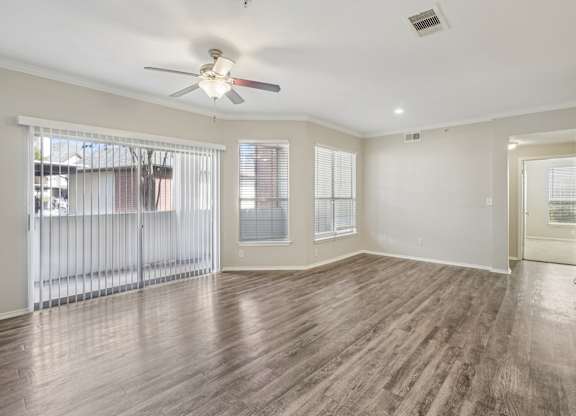 A room with wooden floors and a ceiling fan.