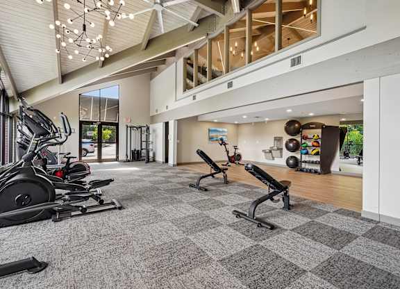 A gym with a variety of equipment including treadmills, weights, and exercise machines.