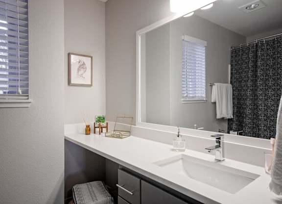 A bathroom with a white sink and a mirror.