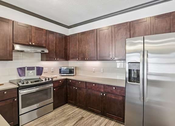 A kitchen with wooden cabinets and stainless steel appliances.