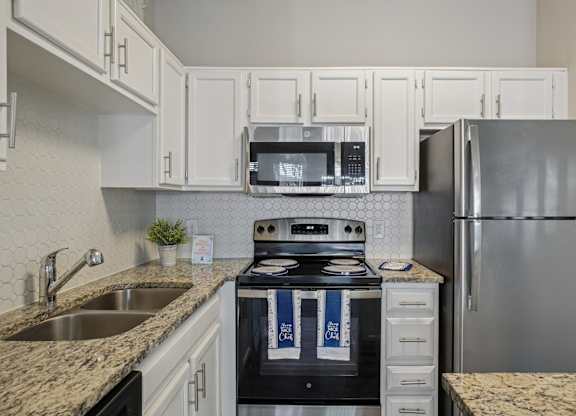 A kitchen with a stove, microwave, and refrigerator.