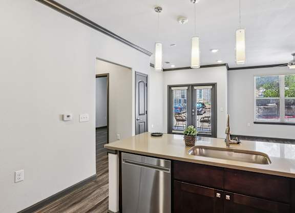 A modern kitchen with a stainless steel dishwasher and a sink.