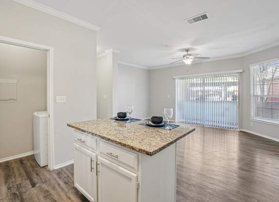 A kitchen with granite countertops and white cabinets.