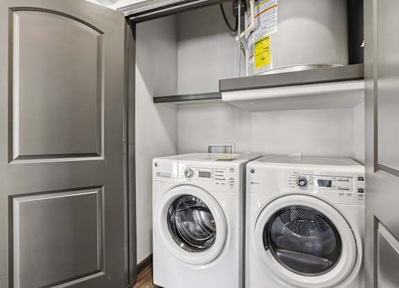 Two white front load washing machines in a laundry room.