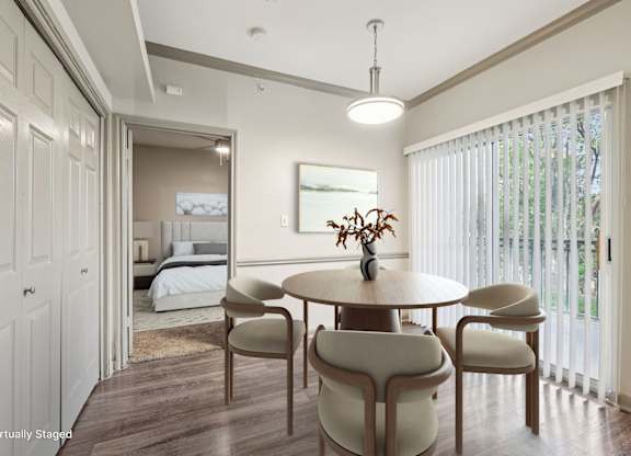 A dining room with a round table and chairs.
