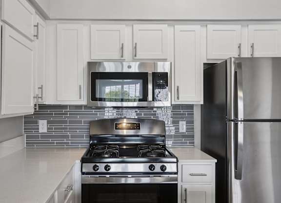 A modern kitchen with a stove and refrigerator.