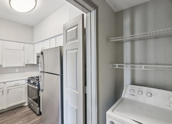A white kitchen with a refrigerator, oven, and dishwasher.