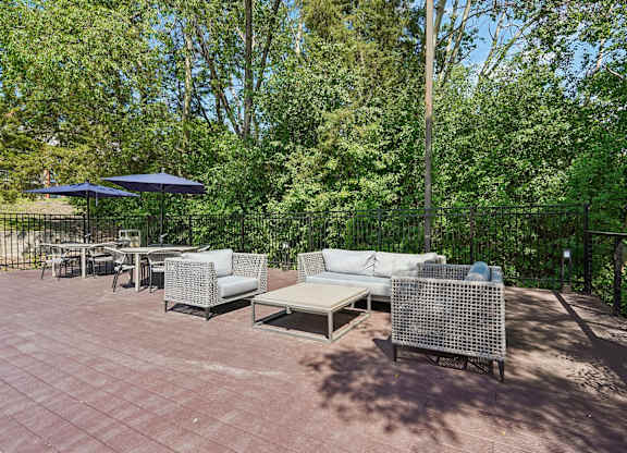 A patio with a table and chairs surrounded by trees.