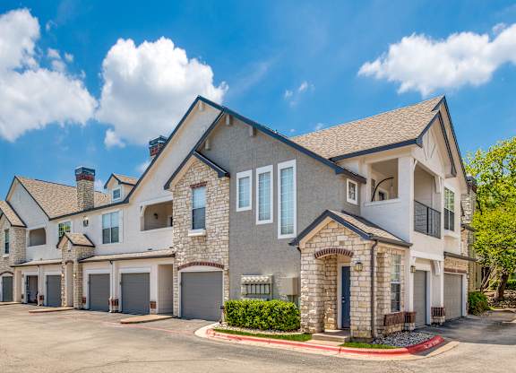 external view of a house with a driveway and garage doors