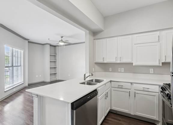 A modern kitchen with white cabinets and stainless steel appliances.
