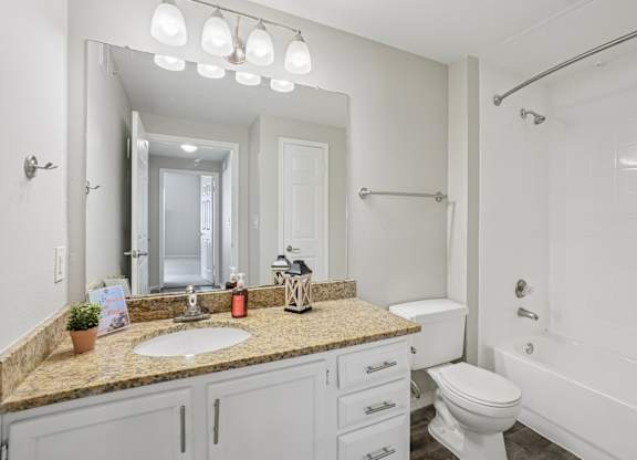 A bathroom with a sink, toilet, and bathtub.