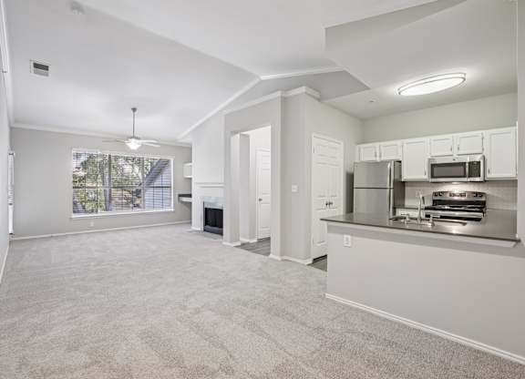 A spacious living area with a kitchenette and a fireplace.