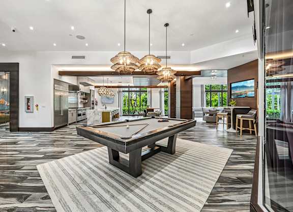 A billiard table is in the middle of a room with a striped rug.