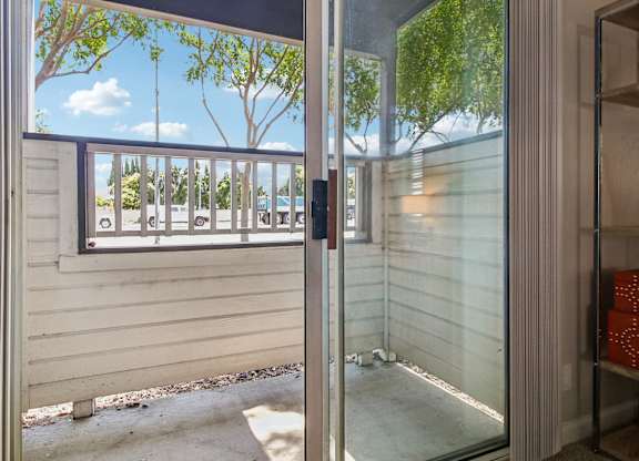A view of a balcony through a glass door.
