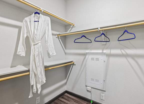 A white robe is hanging on a hanger in a room.