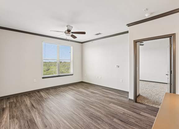 A room with a ceiling fan and a window with blinds.