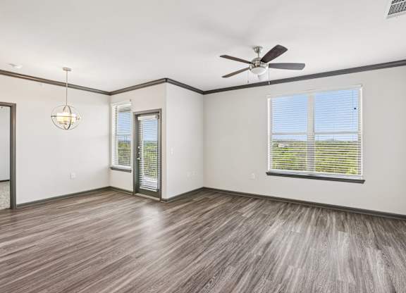 A room with a ceiling fan and wooden flooring.