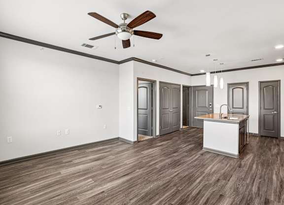 A room with a ceiling fan and wooden flooring.