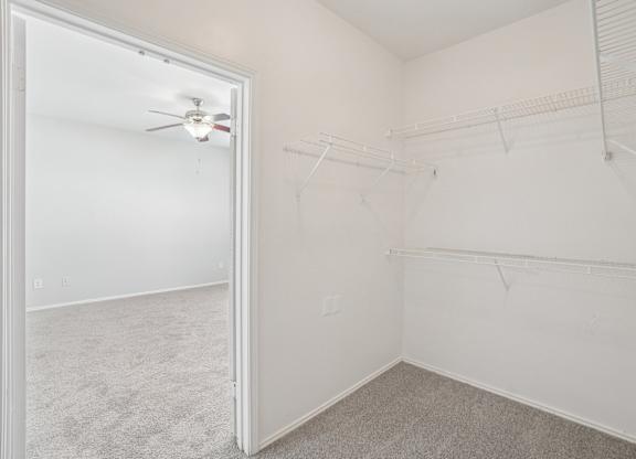 A white room with a ceiling fan and a door.