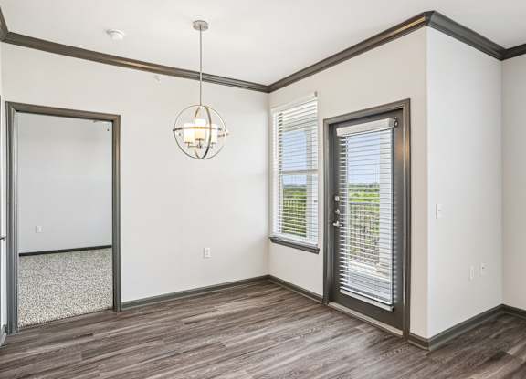 A room with a wooden floor and a hanging light fixture.