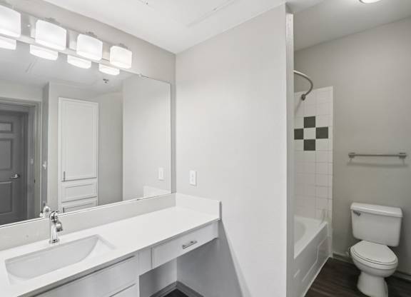 A white bathroom with a toilet, sink, and bathtub.