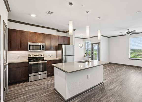 A modern kitchen with a white island and wooden cabinets.