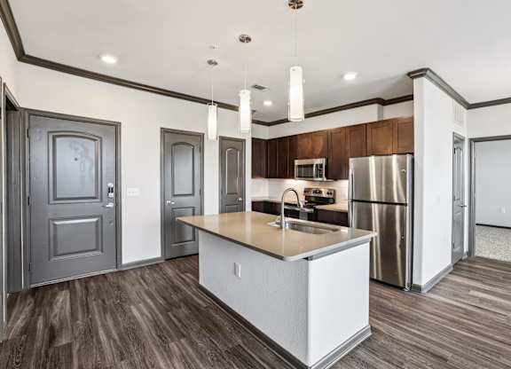 A modern kitchen with a white island and stainless steel appliances.