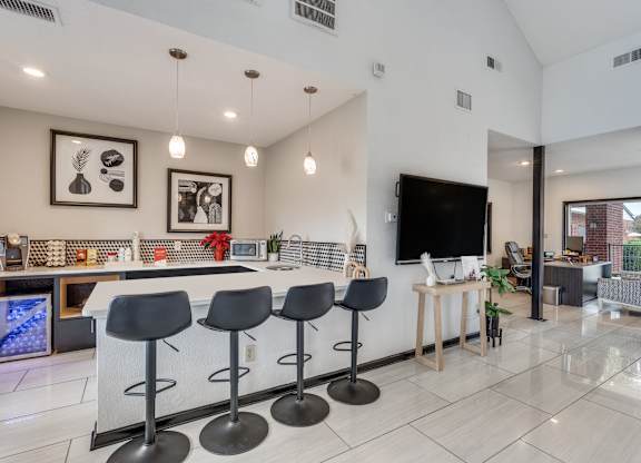 A modern kitchen with a bar area and a television.