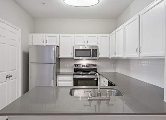 A kitchen with white cabinets and stainless steel appliances.