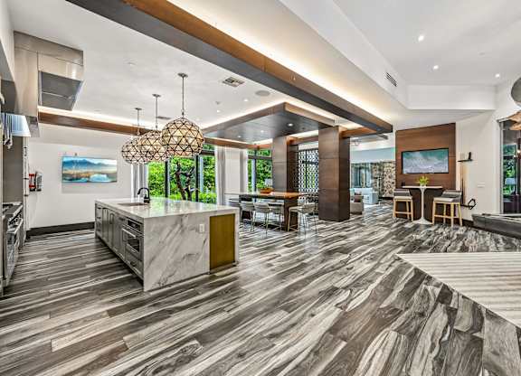 A modern kitchen with a marble island and a pool table.