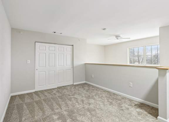 A room with a white door and a carpeted floor.