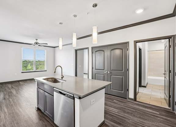 A modern kitchen with a large island and stainless steel appliances.