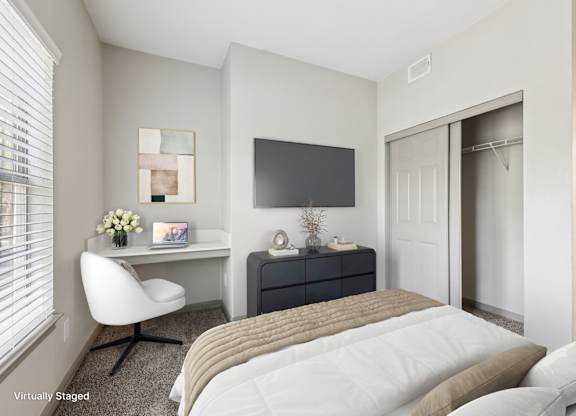 A bedroom with a bed, desk, and chair.