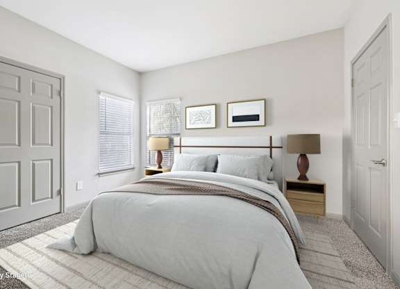A bedroom with a large bed and two nightstands.