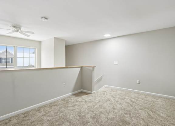 A room with a carpeted floor and a window.