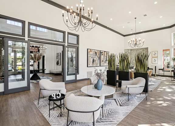 A modern living room with a white sofa set and a chandelier.