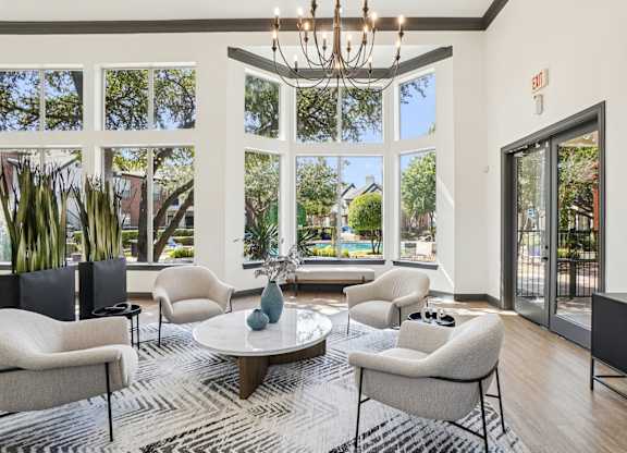 A living room with a chandelier, a sofa, a chair, a table, and a rug.