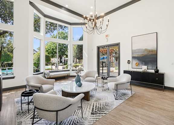 A living room with a large window and a chandelier.