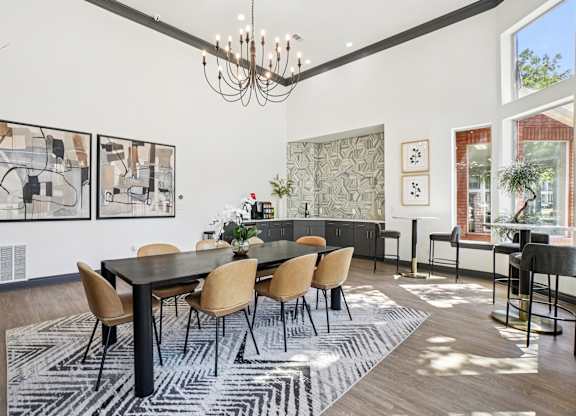 A dining room with a black table and chairs.