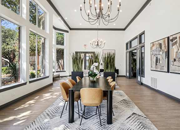 A dining room with a table set for six with chairs around it.
