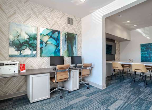 A room with a desk, chairs, and a printer.
