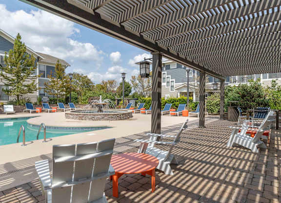 pergola covered seating area next to swimming pool