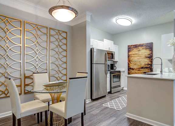 Alpharetta Apartments – The Ascent at Windward – dining room area with hardwood floors and view of kitchen