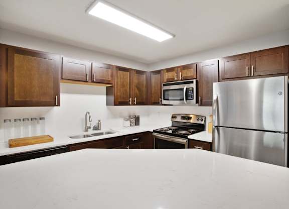 a kitchen with stainless steel appliances and white counter tops